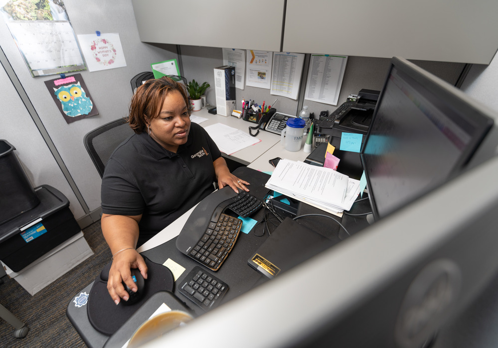 Tech employee sitting at their desk with 3 monitors